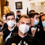 Varios nazarenos con mascarillas de la Hermandad de Santa Genoveva, con mascarillas, en Sevilla