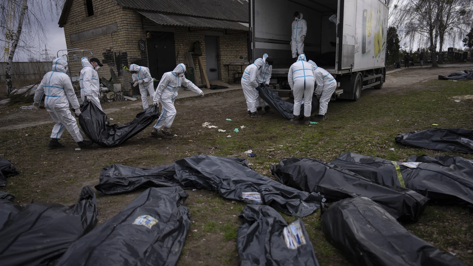 Voluntarios trasladan a una morgue los cadáveres encontrados en la localidad ucraniana de Bucha. (AP Photo/Rodrigo Abd)