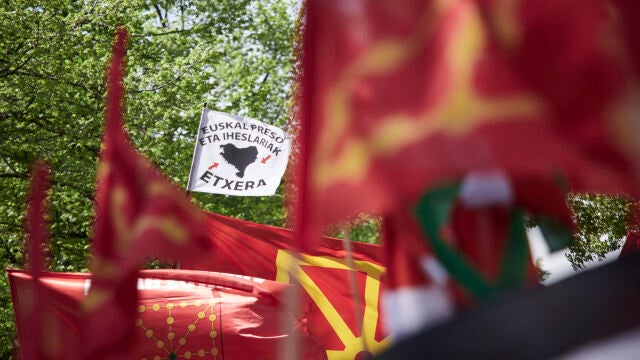 Ikurriñas y banderas de Navarra junto a una pancarta por los presos de ETA en una marcha por el día del Aberri Eguna, en el Paseo de Sarasate, el domingo en Pamplona.
