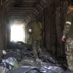 Militares de la milicia de la autoproclamada República Popular de Donetsk observan los cuerpos de los soldados ucranianos colocados en bolsas de plástico en un túnel