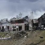 Los bomberos trabajan en la extinción de un incendio tras el impacto de un ataque aéreo en una tienda de neumáticos en Leópolis