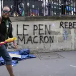 Un hombre pasa junto a un pintada en Saint Denis donde se lee &quot;Ni Le Pen ni Macron&quot;