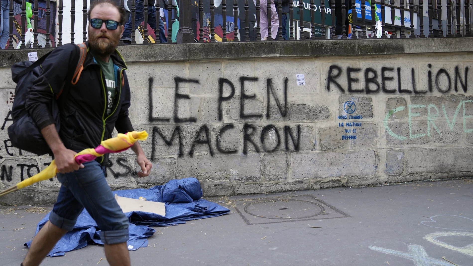 Un hombre pasa junto a un pintada en Saint Denis donde se lee "Ni Le Pen ni Macron"