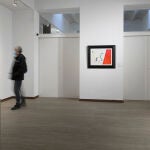 Un visitante contempla las obras en la exposición de la Galeria Mayoral