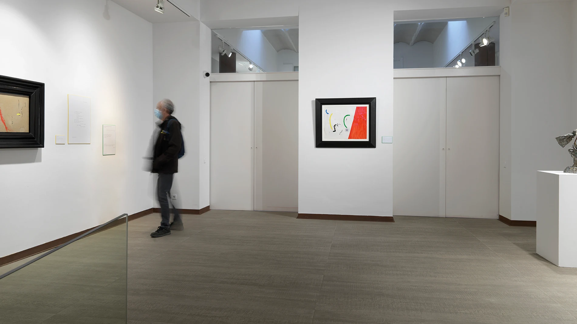 Un visitante contempla las obras en la exposición de la Galeria Mayoral