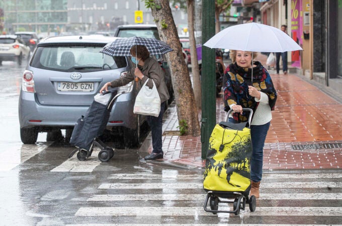 Dos mujeres se protegen de la lluvia este miércoles en la Avenida de la Ronda Norte de Murcia