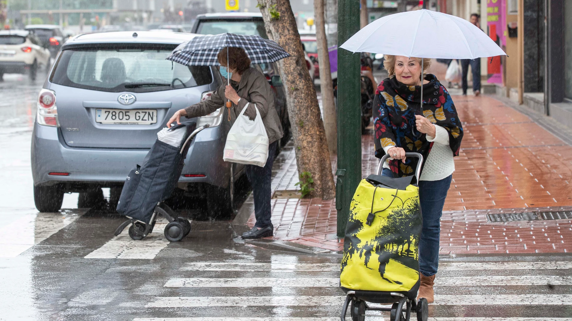 Dos mujeres se protegen de la lluvia este miércoles en la Avenida de la Ronda Norte de Murcia