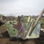 Un soldado ucraniano examina los restos de un caza ruso Su-25 derribado en la localidad de Kolonshchyna, en Ucrania