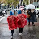 Dos mujeres se protegen de la lluvia en Madrid
