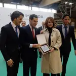 El presidente de la Junta de Andalucía, Juanma Moreno, le entrega una placa a la viuda de Imbroda, Salvadora Acosta