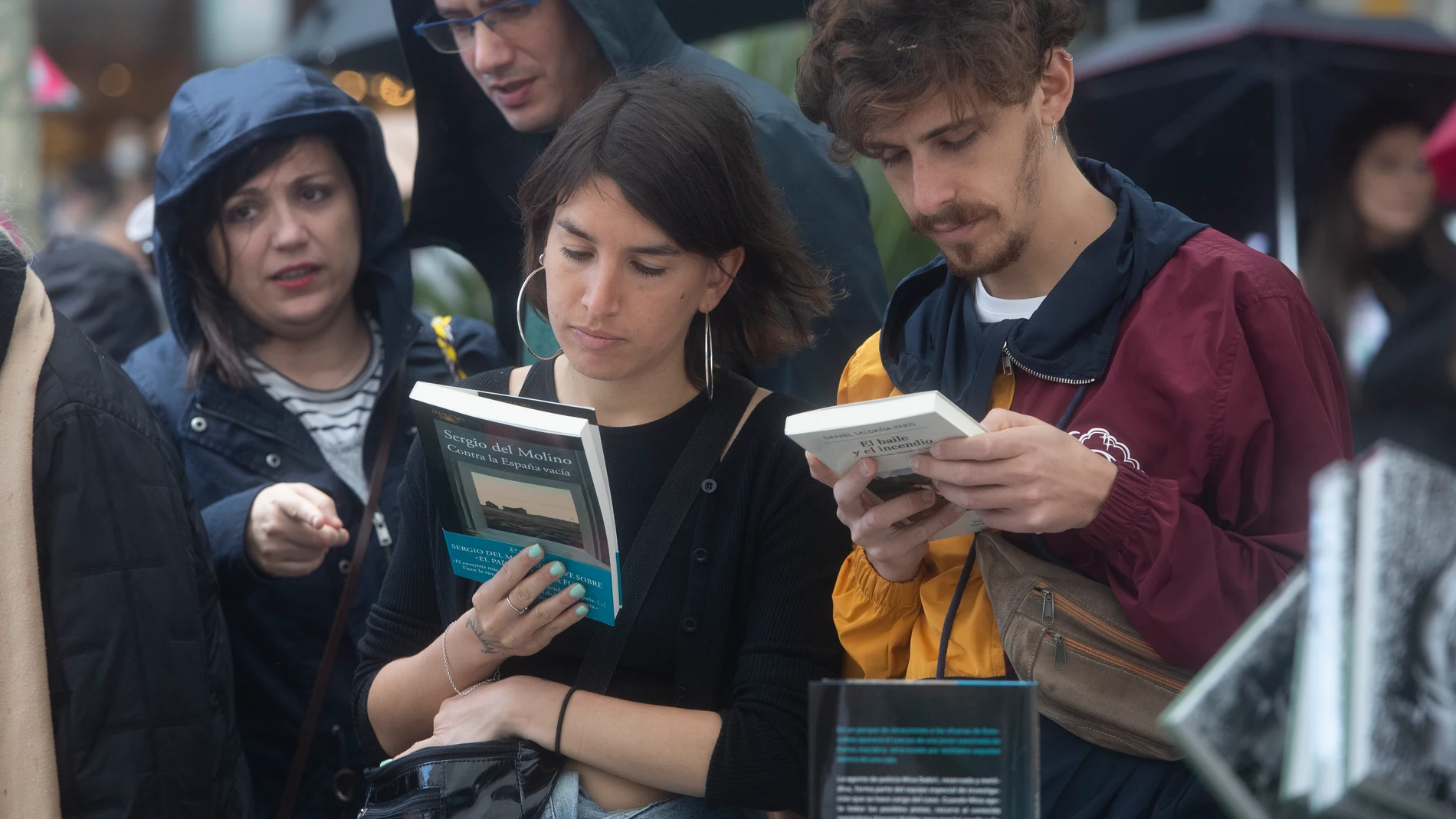 Varias personas compran libros