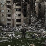 Un soldado ucraniano camina junto a edificio atacado en Jarkov