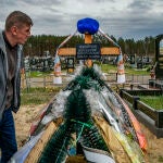 Un hombre visita la tumba de un familiar que murió en el frente durante la ocupación de la ciudad de Slavutych, en el norte de Ucrania