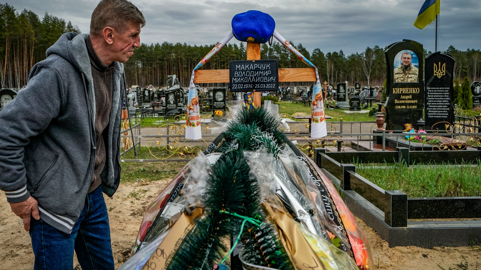 Un hombre visita la tumba de un familiar que murió en el frente durante la ocupación de la ciudad de Slavutych, en el norte de Ucrania