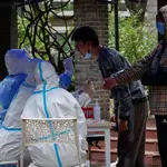 Un hombre se somete a una prueba de COVID-19 en una zona residencial de Beijing, China