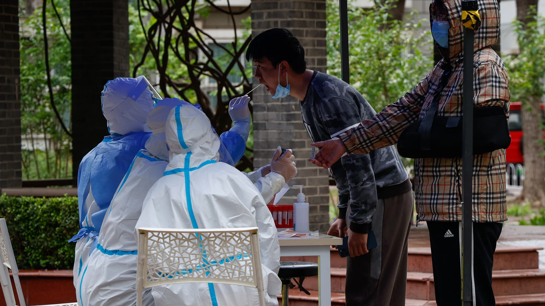 Un hombre se somete a una prueba de COVID-19 en una zona residencial de Beijing, China