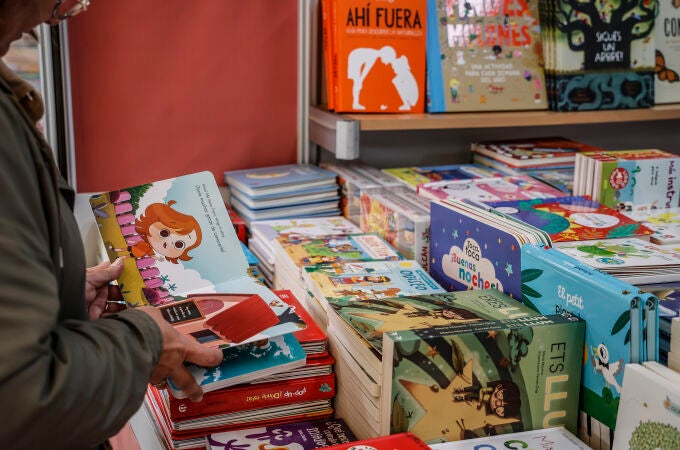 Una persona consulta un libro durante la inauguración de la Feria del Libro 2022, en los Jardines de Viveros de Valencia