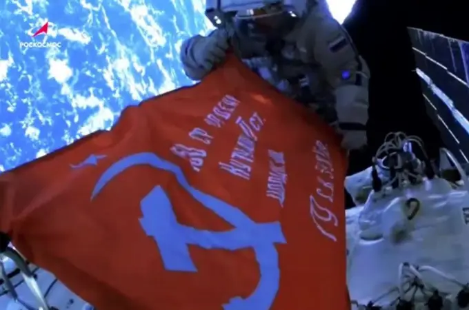 Dos cosmonautas rusos exhiben la Bandera de la Victoria, con la hoz y el martillo soviéticos, en la Estación Espacial Internacional 