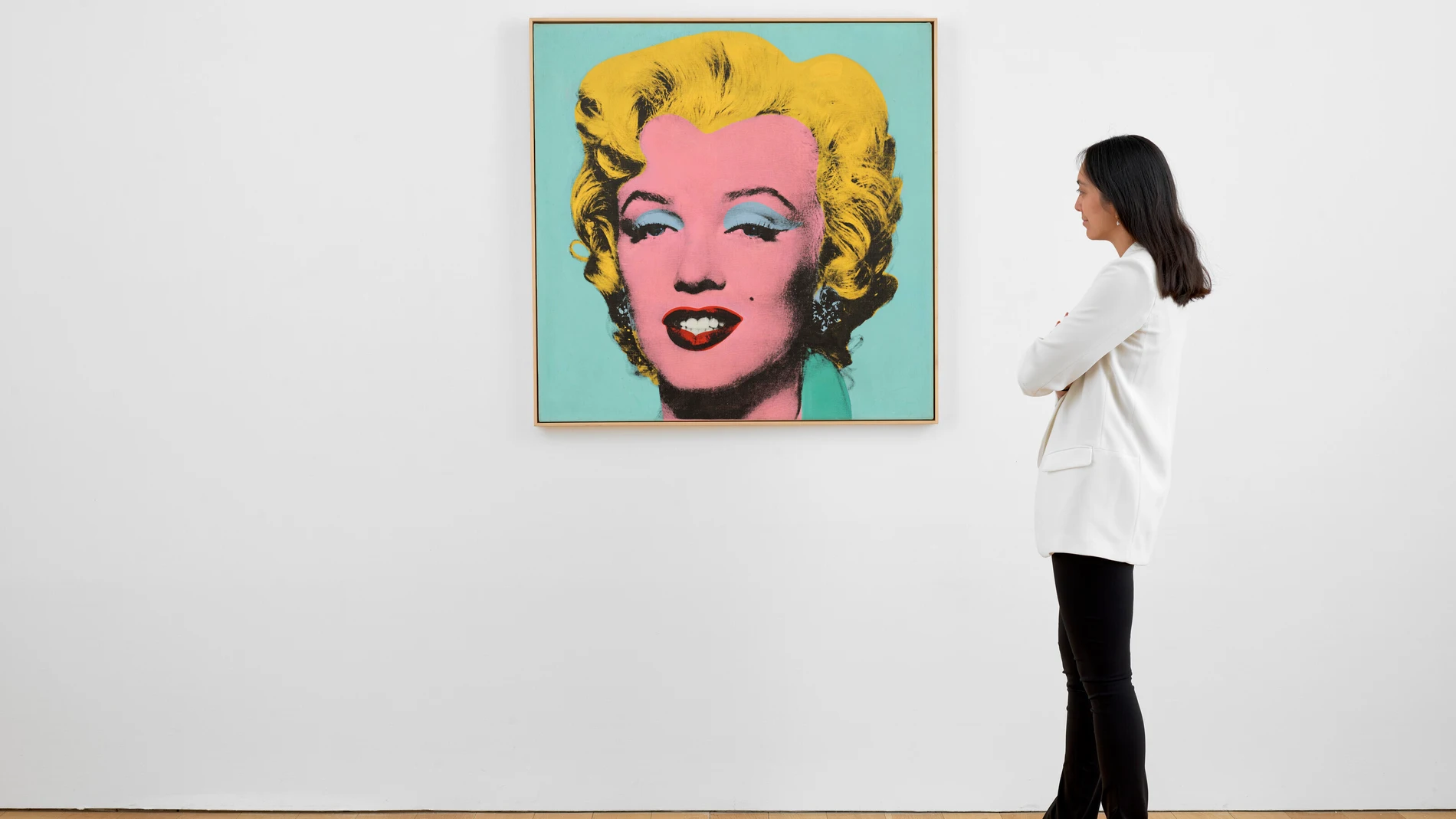 Una mujer observa la obra "Shot Sage Blue Marilyn", un llamativo retrato ejecutado por el artista estadounidense Andy Warhol en 1964 que hoy se pone a la venta