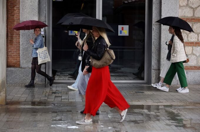 Varias personas caminan con paraguas en Madrid