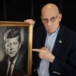 El escritor James Ellroy posa junto con un retrato de John F. Kennedy