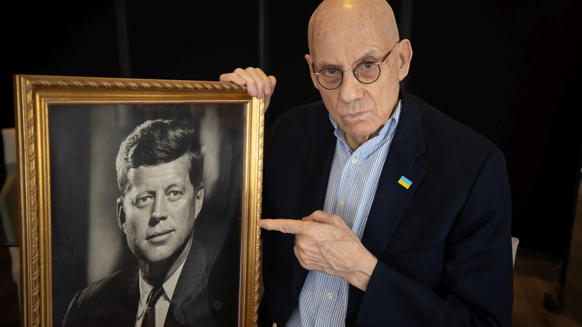 El escritor James Ellroy posa junto con un retrato de John F. Kennedy