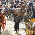 Una mujer pasea en medio del paseo de caballos durante la jornada del domingo en el Real de la Feria de Abril