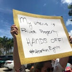 Una mujer sostiene una pancarta que dice "Mi útero es propiedad privada, ¡No lo toques!" durante un acto celebrado este martes a las afueras de la llamada Torre de la Libertad en Miami, Florida.