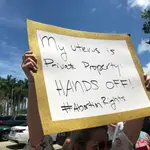 Una mujer sostiene una pancarta que dice &quot;Mi útero es propiedad privada, ¡No lo toques!&quot; durante un acto celebrado este martes a las afueras de la llamada Torre de la Libertad en Miami, Florida.
