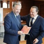 Carlos Pollán, presidente de las Cortes, bromea con el de Cuentas, Mario Amilivia, tras recibir la memoria de 2021