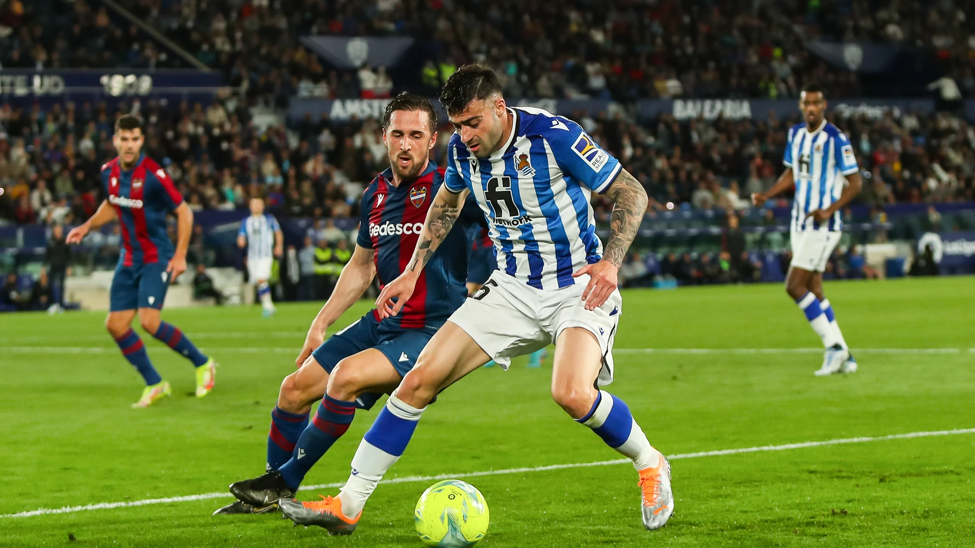 Diego Rico y Jorge Miramon pelean por un balón en el Levante - Real Sociedad