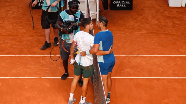 Carlos Alcaraz y Rafa Nadal se saludan en la red después del partido de cuartos de final que disputaron en el Mutua Madrid Open
