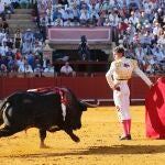 Manuel Escribano comienza la faena con un pase cambiado por la espalda, en Sevilla