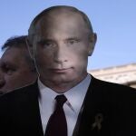 A man holds a cutout of Russian President Vladimir Putin during the Victory Day ceremony in Belgrade, Serbia, Monday, May 9, 2022 on the occasion of the 77th anniversary of the victory over Nazi Germany in WWII. (AP Photo/Darko Vojinovic)