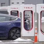 FILE - A Tesla electric vehicle, left, sits in a charging station at a dealership, Thursday, Feb. 18, 2021, in Dedham, Mass. Shares of Tesla and Twitter have tumbled this week as investors deal with the fallout and potential legal issues surrounding Tesla CEO Elon Musk and his $44 billion bid to buy the social media platform. Of the two, Musk's electric vehicle company has fared worse, with its stock down almost 16% so far this week to $728. (AP Photo/Steven Senne, File)