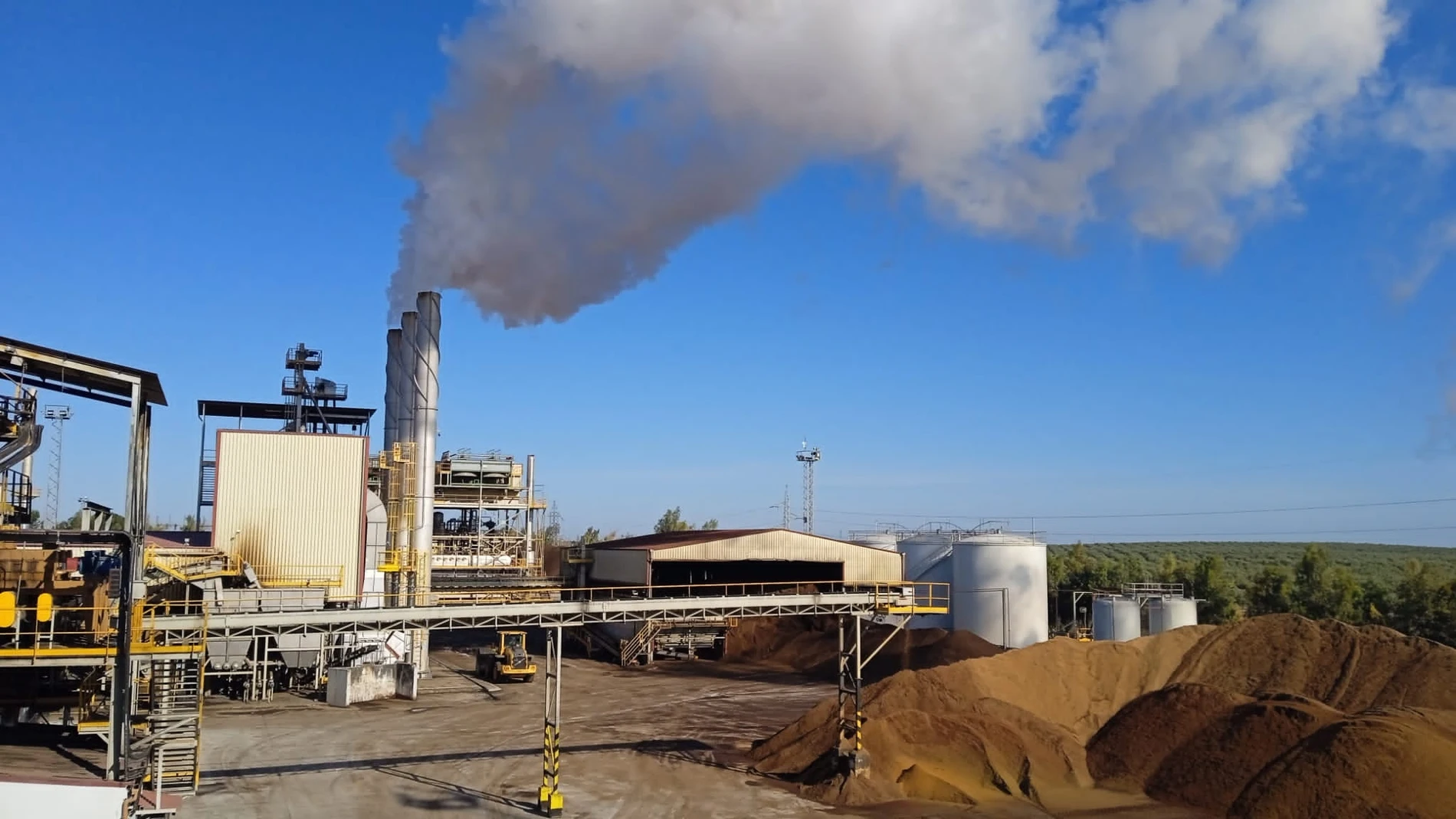 Vista de una planta extractora de aceite de orujo, con el vapor de agua producto del secado del OGH saliendo por las chimeneas