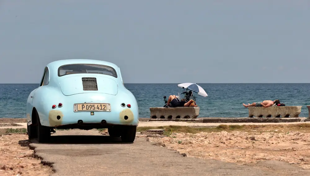 Varias personas toman el sol junto al mar, en La Habana