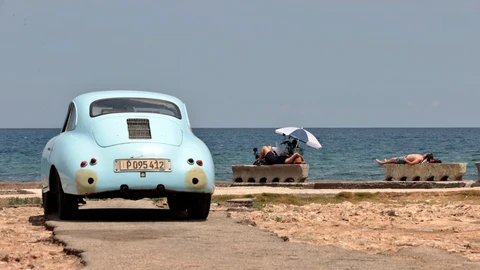 Varias personas toman el sol junto al mar, en La Habana
