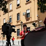 Un equipo de televisión trabaja ante la comisaría de Zapadores donde se encontraban los cinco menores detenidos por las supuestas agresiones sexuales que habrían sufrido el pasado lunes dos niñas en la localidad valenciana de Burjassot