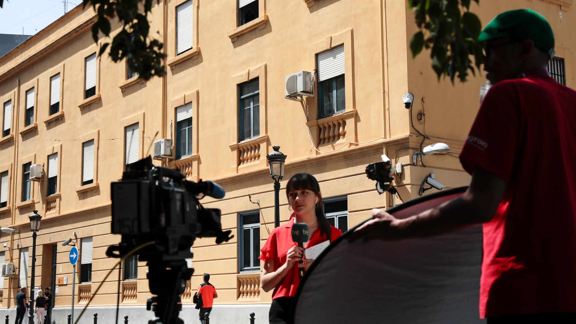 Un equipo de televisión trabaja ante la comisaría de Zapadores donde se encontraban los cinco menores detenidos por las supuestas agresiones sexuales que habrían sufrido el pasado lunes dos niñas en la localidad valenciana de Burjassot