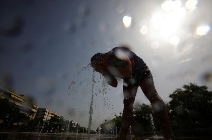 Un hombre se moja con agua de una fuente en Córdoba
