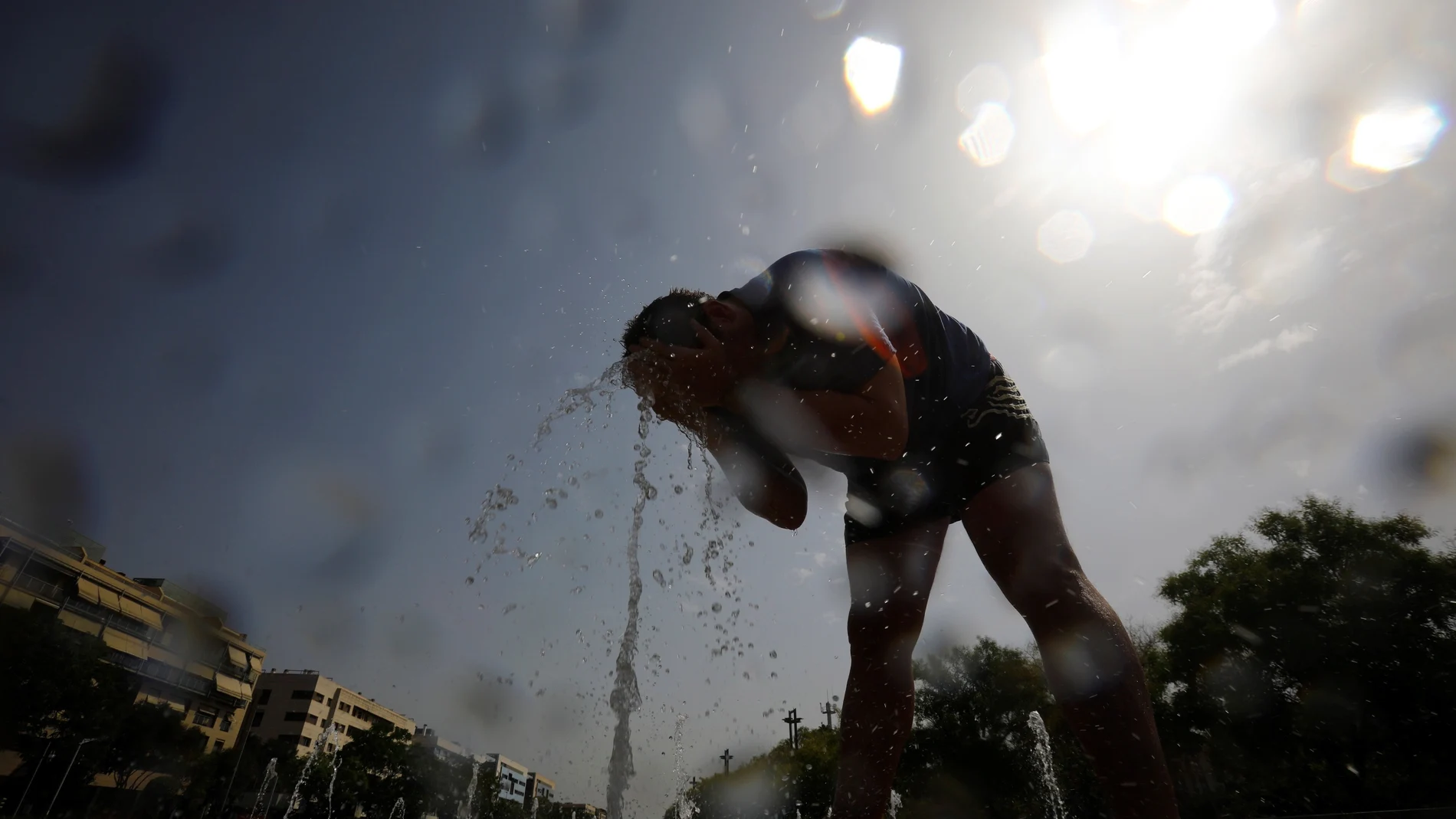 Un hombre se moja con agua de una fuente en Córdoba ante el asfixiante calor