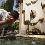 Un turista se refresca en una de las fuentes del patio de los naranjos de la Mezquita-Catedral de Córdoba
