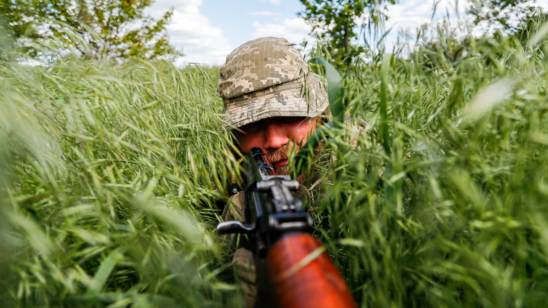 Un soldado ucraniano de una unidad de inteligencia se esconde en la hierba durante una operación de patrulla y vigilancia en las afueras de la región separatista de Donetsk (Donbás)