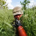 Un soldado ucraniano de una unidad de inteligencia se esconde en la hierba durante una operación de patrulla y vigilancia en las afueras de la región separatista de Donetsk (Donbás)