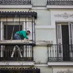Un trabajador repara el balcón de una vivienda en Madrid