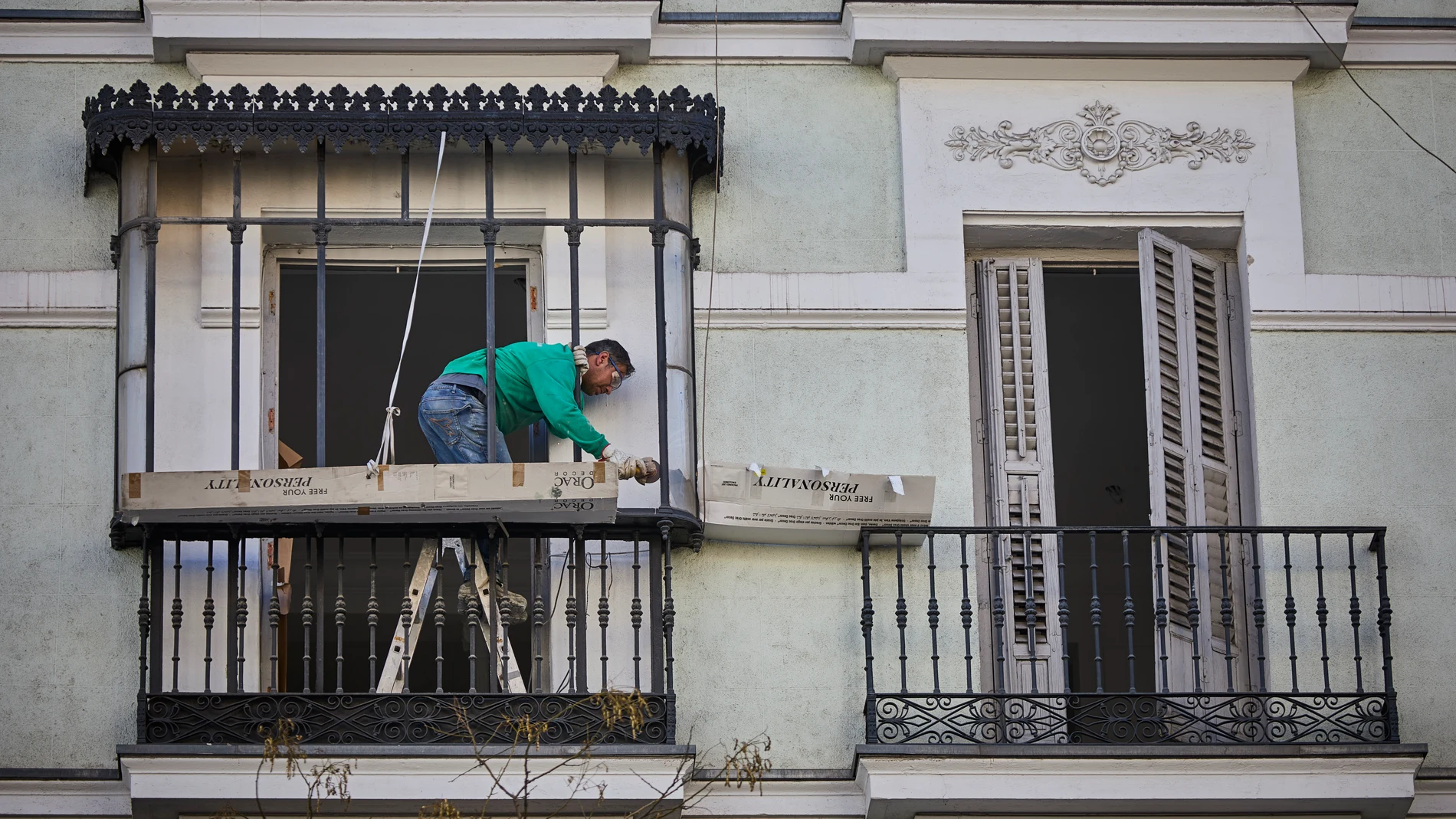 Un trabajador repara el balcón de una vivienda en Madrid