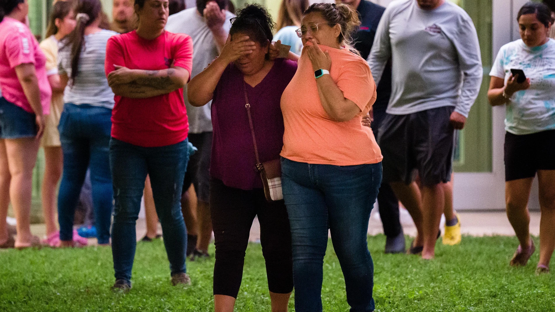 Dos mujeres esperan noticias de lo ocurrido en la Escuela Primaria de Uvalde, Texas, después de que un joven asesinara a 21 personas, 19 de ellas niños.