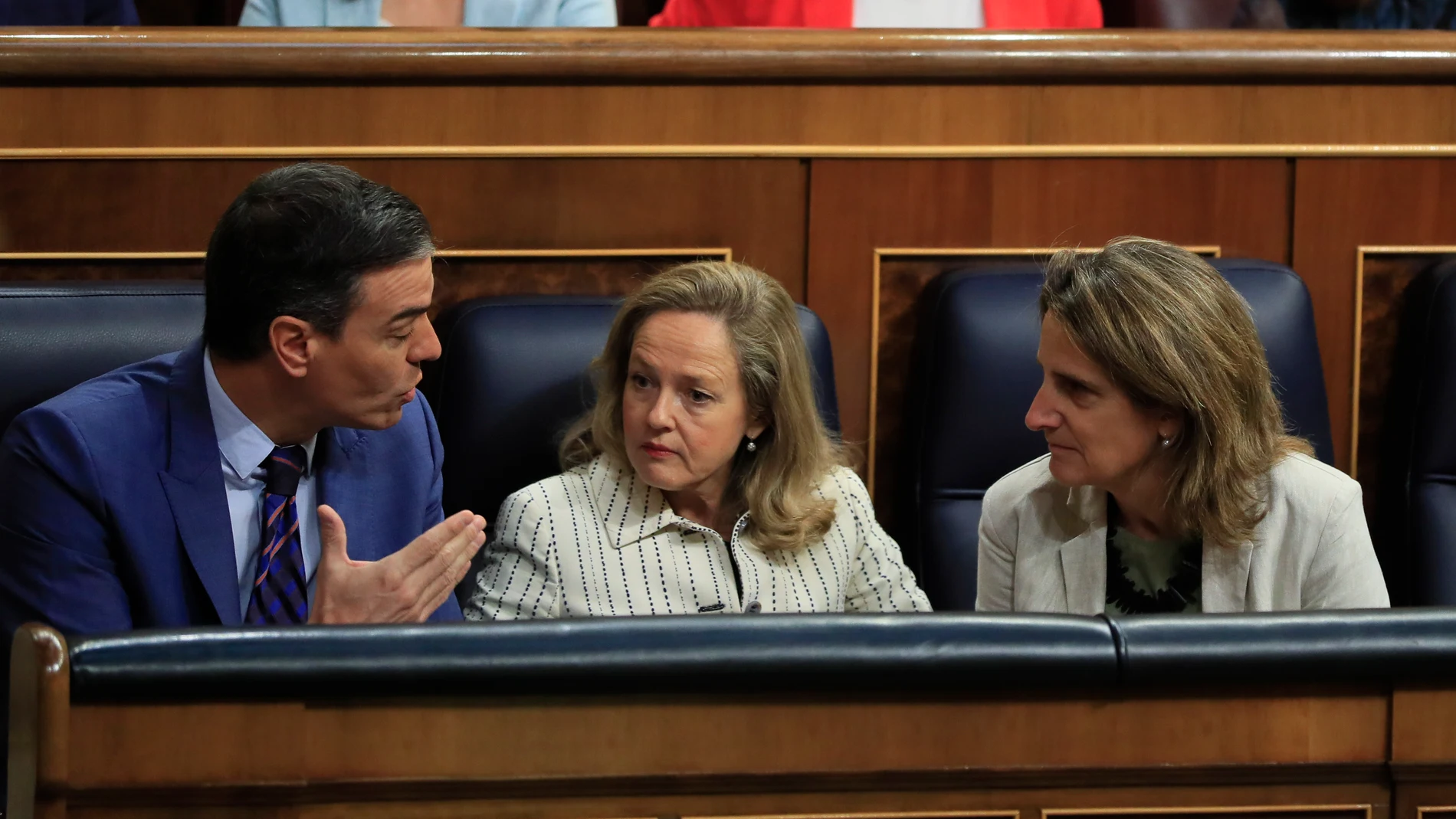 El presidente del Gobierno, Pedro Sánchez (i) conversa con las vicepresidentas Nadia Calviño (c) y Teresa Ribera (d) en el Congreso de los Diputados
