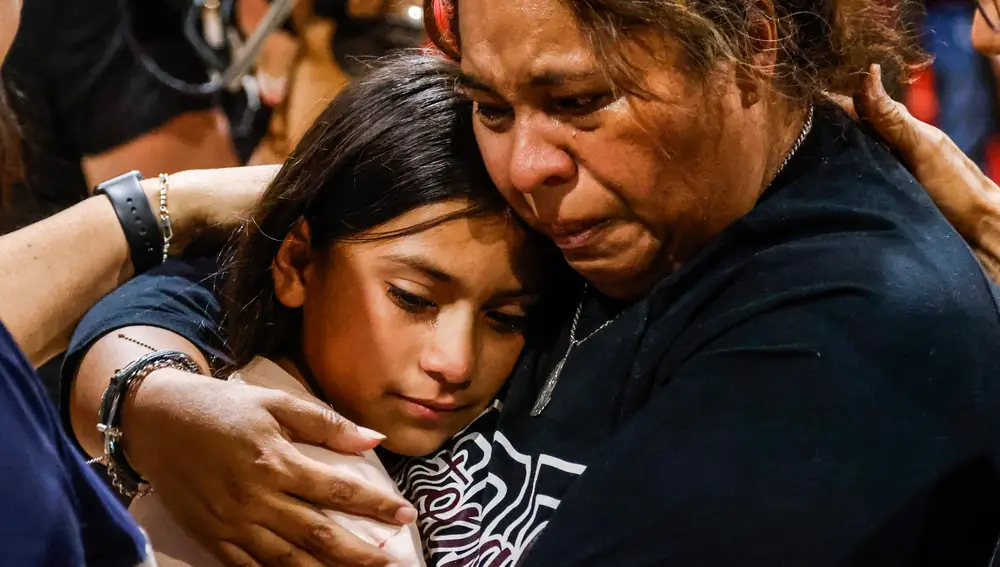 Un mujer abraza una niña en una reunión de vecinos en Uvalde, el pueblo de Texas donde se produjo un tiroteo que acabó con la vida de 21 personas
